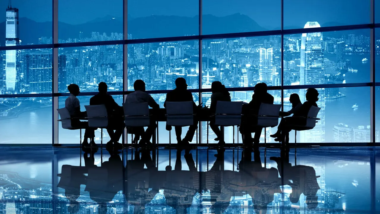 Team meeting in a boardroom with a city view at night